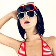 Portrait of a girl in a fashionable swimsuit and sunglasses.