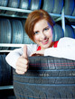 Female apprentice showing thumb up for tire changing