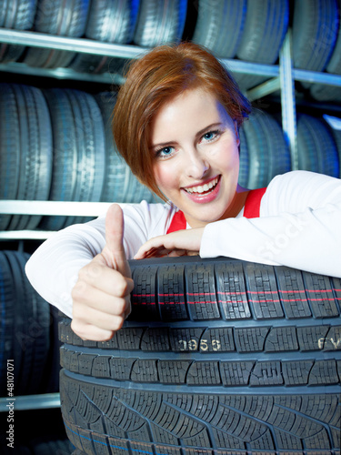 Photo: Female apprentice showing thumb up for tire changing Female apprentice showing thumb up for tire changing