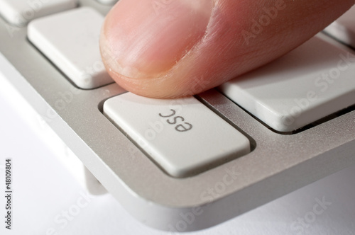 Photo: Finger pressing ESC key Finger pressing ESC key