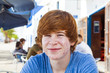 smart boy in puberty sitting on an outdoor table in the village
