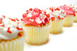 Row of pink and white Valentines Day cupcakes over white