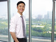 young asian businessman standing by the window