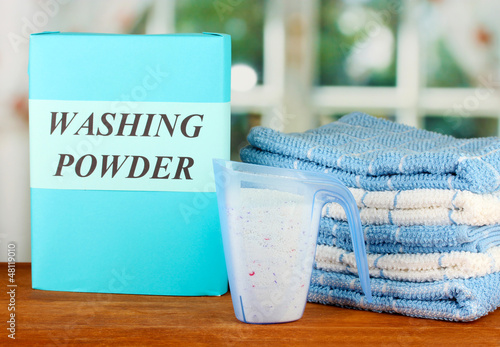 Photo: Box of washing powder with blue measuring cup and towels, Box of washing powder with blue measuring cup and towels,