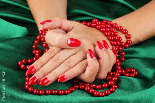 Photo: Female hands holding beads on color background Female hands holding beads on color background