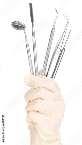 Photo: Dental tools in dentists hands isolated on white Dental tools in dentists hands isolated on white