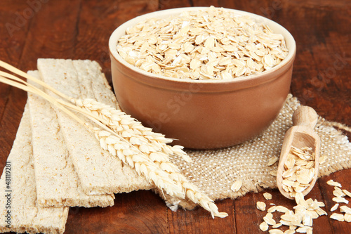 Photo: Oat flakes in brown bowl on the table Oat flakes in brown bowl on the table
