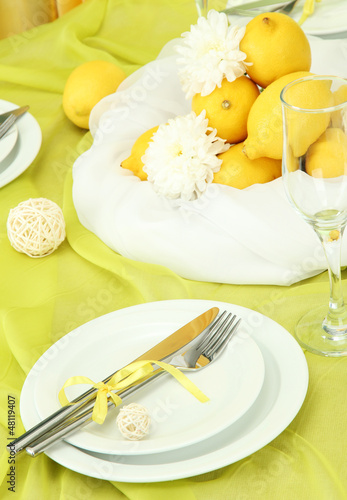 Photo: beautiful holiday table setting with lemons, close up beautiful holiday table setting with lemons, close up