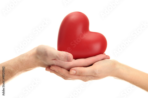 Photo: Red heart in woman and man hands, isolated on white Red heart in woman and man hands, isolated on white