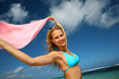 Attractive girl at the beach with pareo in the wind
