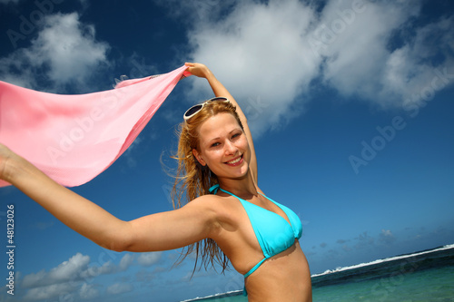 Photo: Attractive girl at the beach with pareo in the wind Attractive girl at the beach with pareo in the wind