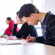 Photo: young, handsome male college student sitting in a classroom young, handsome male college student sitting in a classroom