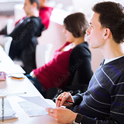 Photo: young, handsome male college student sitting in a classroom young, handsome male college student sitting in a classroom