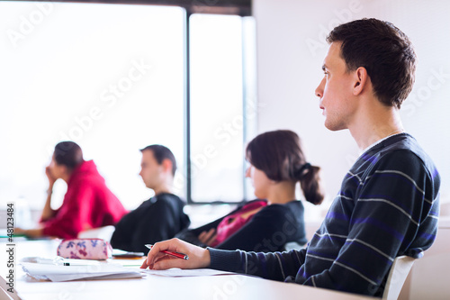 Photo: young, handsome male college student sitting in a classroom young, handsome male college student sitting in a classroom