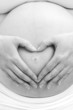 Pregnant woman making a heart sign