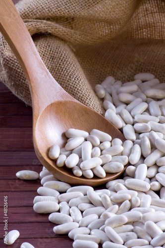 Photo: White beans - Cannellini (legumes) in a wooden spoon and bag White beans - Cannellini (legumes) in a wooden spoon and bag