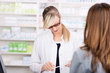 apothekerin schaut auf ein rezept