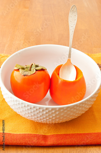 Photo: Persimmons in bowl with spoon Persimmons in bowl with spoon