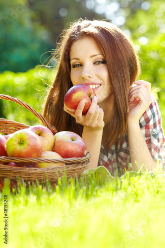 Photo: Beautiful woman in the garden with apples Beautiful woman in the garden with apples