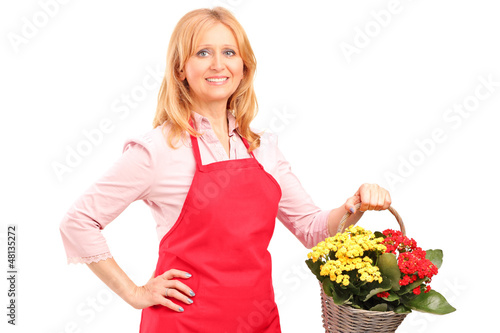 Photo: A mature florist holding a basket full of flowers A mature florist holding a basket full of flowers