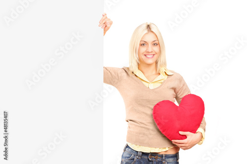 Photo: A young female holding a blank panel and red heart A young female holding a blank panel and red heart