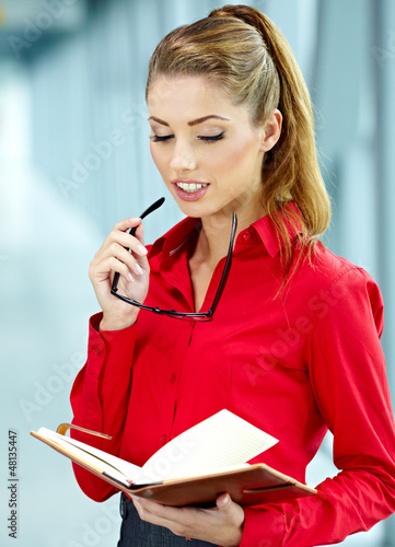 Photo: A portrait of a young business woman in an office A portrait of a young business woman in an office