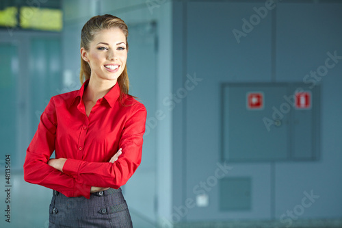 Photo: Portrait of happy smiling young businesswoman in office Portrait of happy smiling young businesswoman in office