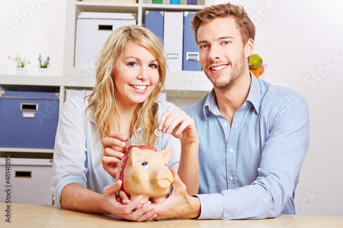 Photo: Paar spart Geld mit Sparschwein Paar spart Geld mit Sparschwein