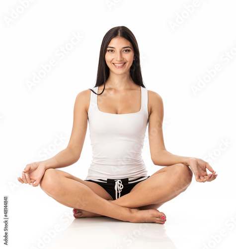 Photo: Happy young woman sitting in lotus position Happy young woman sitting in lotus position