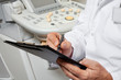 Male Doctor Writing On Clipboard