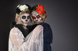 Two women in skull make-up.