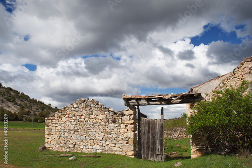 Photo: ruins of an old farmhouse in the green field ruins of an old farmhouse in the green field