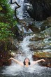 Woman in wild waterfall