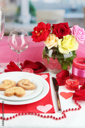 Photo: Table setting in honor of Valentine's Day on room background Table setting in honor of Valentine's Day on room background