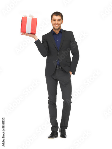 Photo: handsome man in suit with a gift box handsome man in suit with a gift box