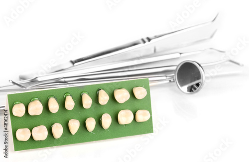 Photo: denture with dental tools isolated on white denture with dental tools isolated on white