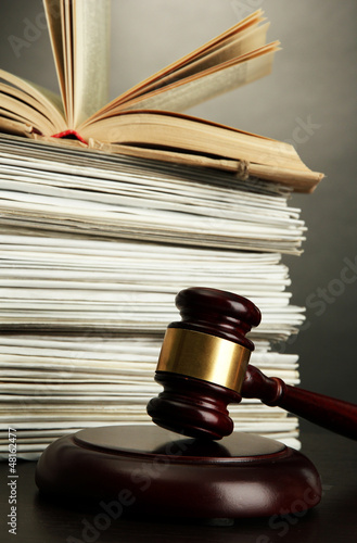 Photo: gavel and old papers on grey background gavel and old papers on grey background