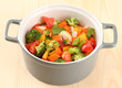 Vegetable stew in gray pot on wooden background