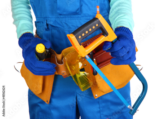 Photo: Male builder in blue overalls with saw isolated on white Male builder in blue overalls with saw isolated on white