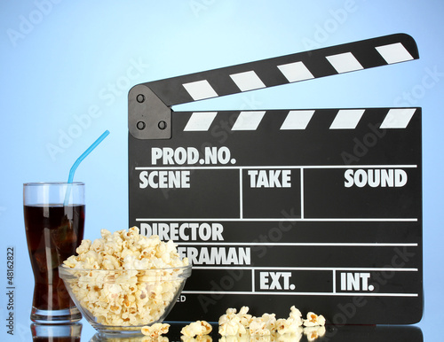 Photo: Movie clapperboard, cola and popcorn on blue background Movie clapperboard, cola and popcorn on blue background