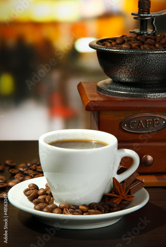 Photo: cup of coffee, grinder and coffee beans in cafe cup of coffee, grinder and coffee beans in cafe