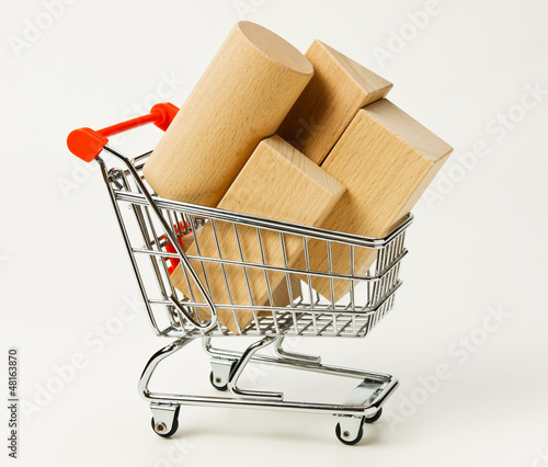 Photo: wooden blocks for the construction in shopping trolley on a whit wooden blocks for the construction in shopping trolley on a whit