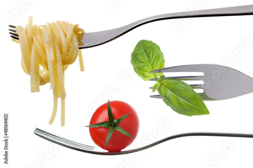 Photo: spaghetti basil and tomato on forks isolated spaghetti basil and tomato on forks isolated
