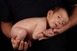 Baby boy without clothes in dads hands