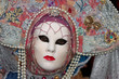 Person in Venetian costume attends Carnival of Venice.