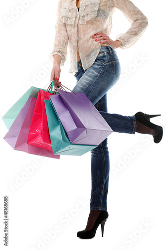 Photo: Shopping bags near legs in jeans Shopping bags near legs in jeans