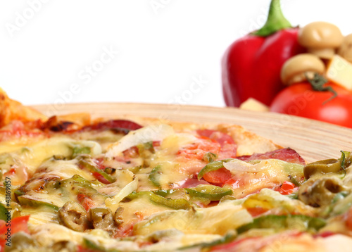 Photo: Image of sliced pizza in a plate and vegetables Image of sliced pizza in a plate and vegetables