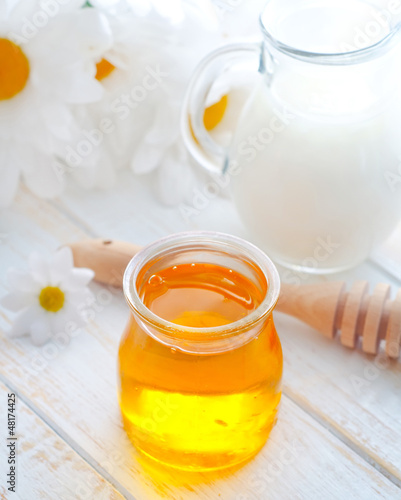Photo: fresh honey in the glass bank and milk in jug fresh honey in the glass bank and milk in jug