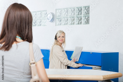 Photo: Receptionist Looks At Woman In Dentist's Office Receptionist Looks At Woman In Dentist's Office