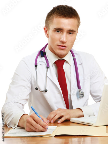 Photo: A male doctor working at desk, isolated on white background A male doctor working at desk, isolated on white background